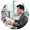 ATM technical operations manager reviewing maintenance records in a Singapore service office